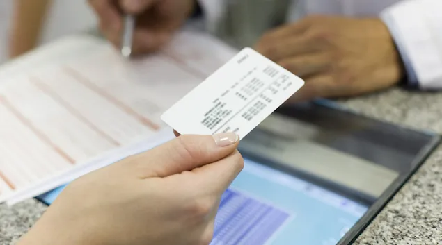 Patient handing over insurance card