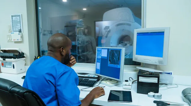 Healthcare worker controlling an MRI machine