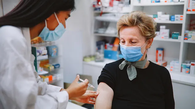 Pharmacist administers a vaccine to an elderly patient