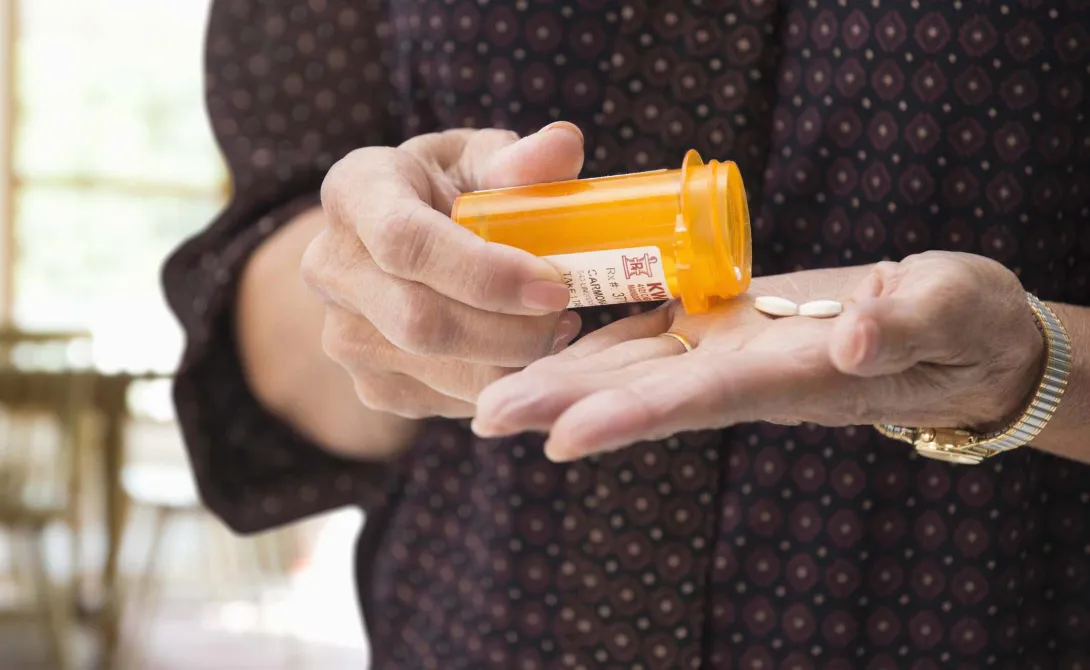 Hands dispensing pills from a bottle