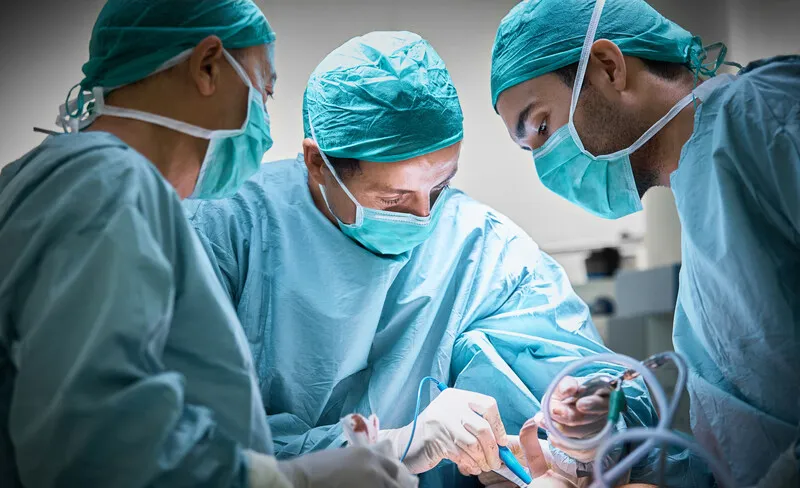 An operation setting with three medical professionals. Photo: Morsa/Getty Images