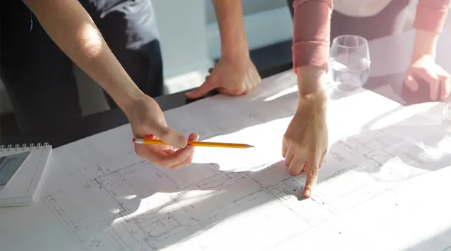 Hands pointing over blueprints