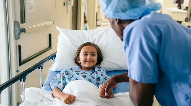 Healthcare worker visits child in hospital bed