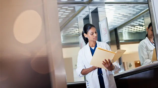 A medical professional examines a chart.