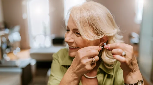 person putting on hearing aid