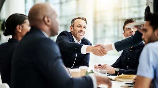 Business handshake over meeting table