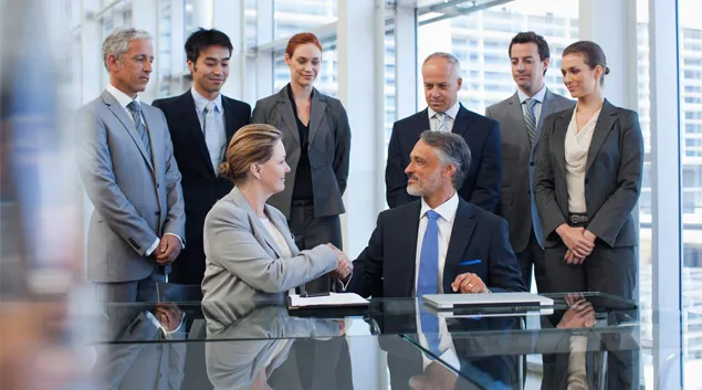 Merger handshake in a conference room
