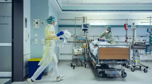 Person in PPE in hospital room