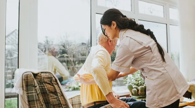 Nurse helping person out of chair