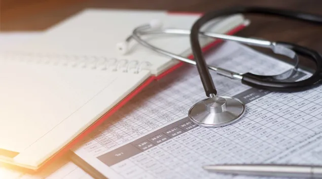 A stethoscope set on paperwork