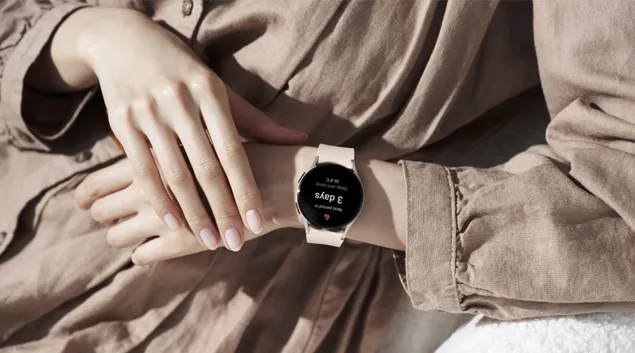 One hand reaches for smartwatch on opposite wrist